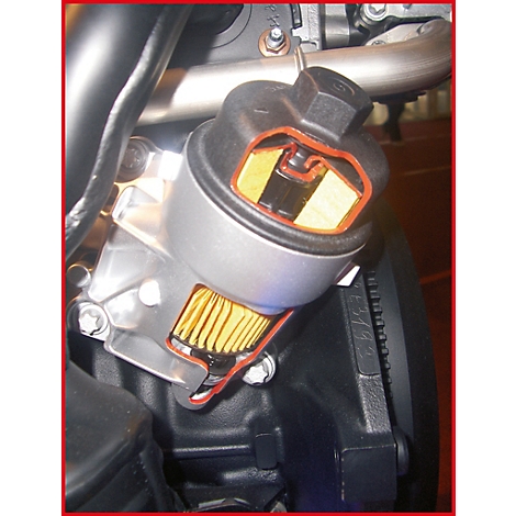 Schnitt durch einen Ölfilter, Innenleben erkennbar. Gelbes Filtermedium, rote Dichtungen, schwarzer Deckel und Metallgehäuse.